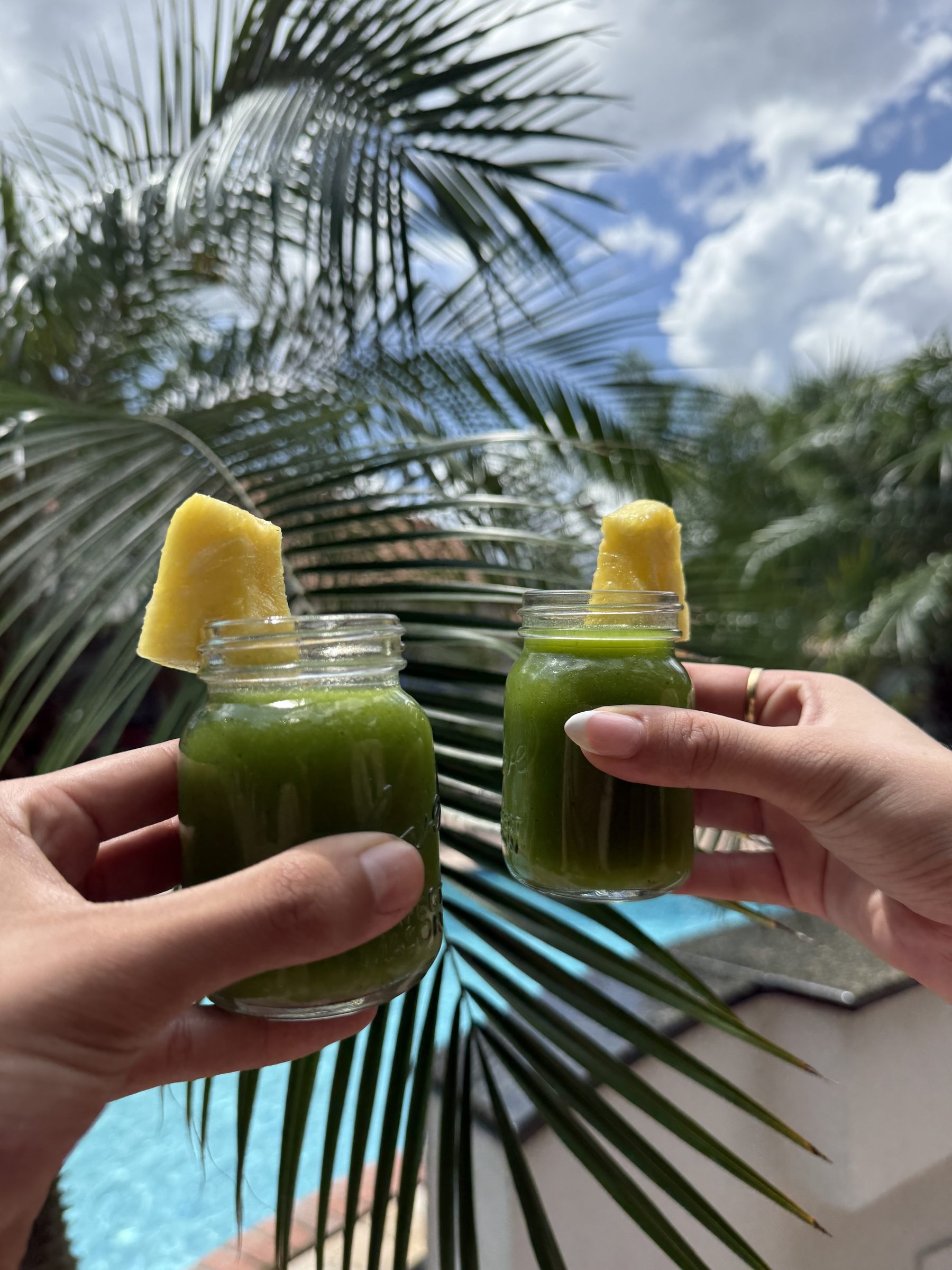 Two people sharing an early green juice batch outdoors in Florida
